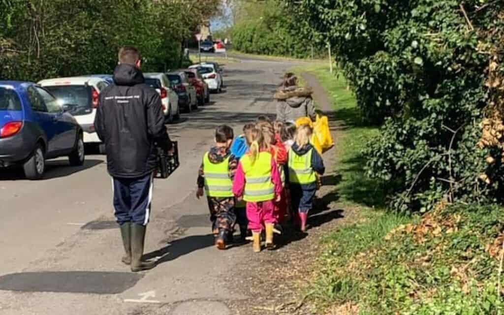 children walking down the road in hi vest jackets